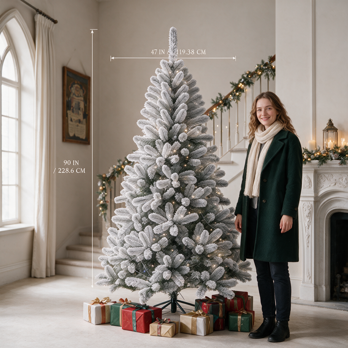 White flocked Christmas tree size guide showing a height of 90 inches (228.6 cm) and a width of 47 inches (119.38 cm), with a woman standing beside the tree for scale.