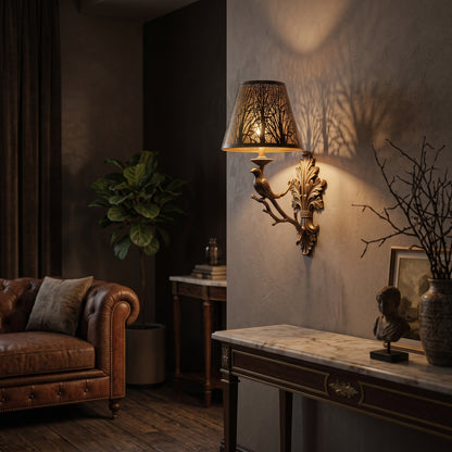 Vintage wall sconce lamp shade with small metal forest pattern, casting soft ambient shadows on a textured wall.