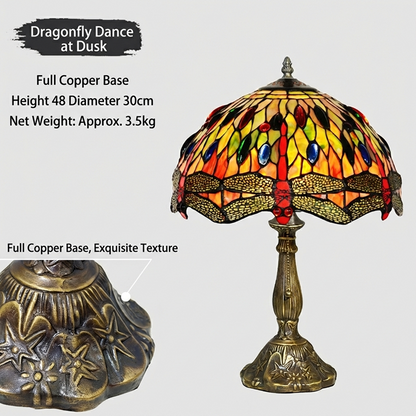 Tiffany style dragonfly table lamp illuminated with warm golden glow through stained glass creating elegant nature inspired ambiance