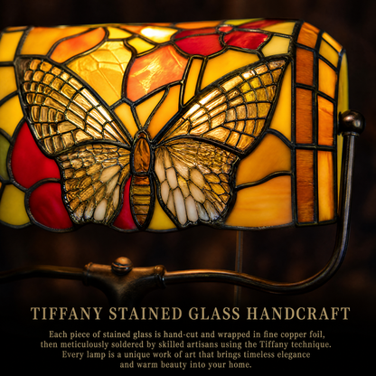 Close-up of Tiffany style butterfly banker lamp showing handcrafted stained glass butterfly and colorful floral pattern