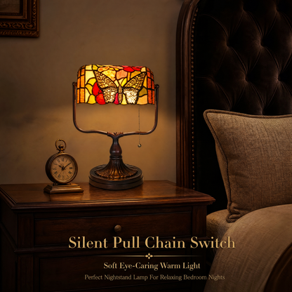 Tiffany style butterfly stained glass banker lamp with pull-chain switch on a vintage bedroom nightstand