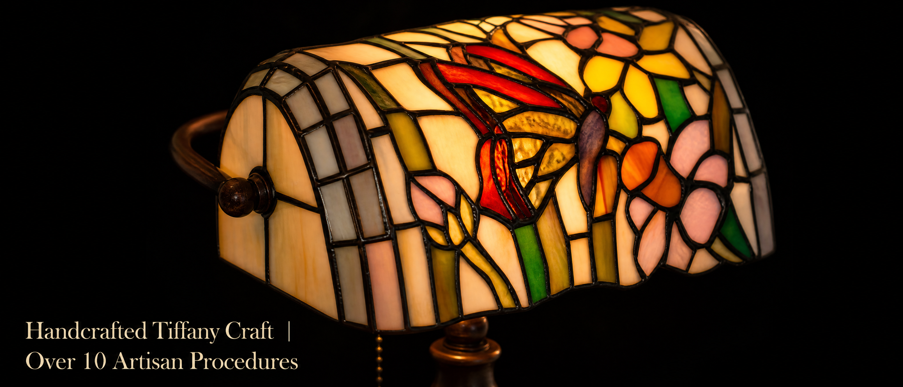 Close-up of Tiffany style butterfly banker lamp showing colorful stained glass butterfly, floral patterns and artisan-style glass details