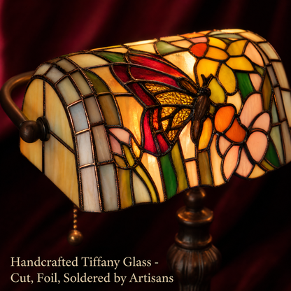 Close-up of Tiffany style butterfly banker lamp showing handcrafted stained glass butterfly and floral shade details