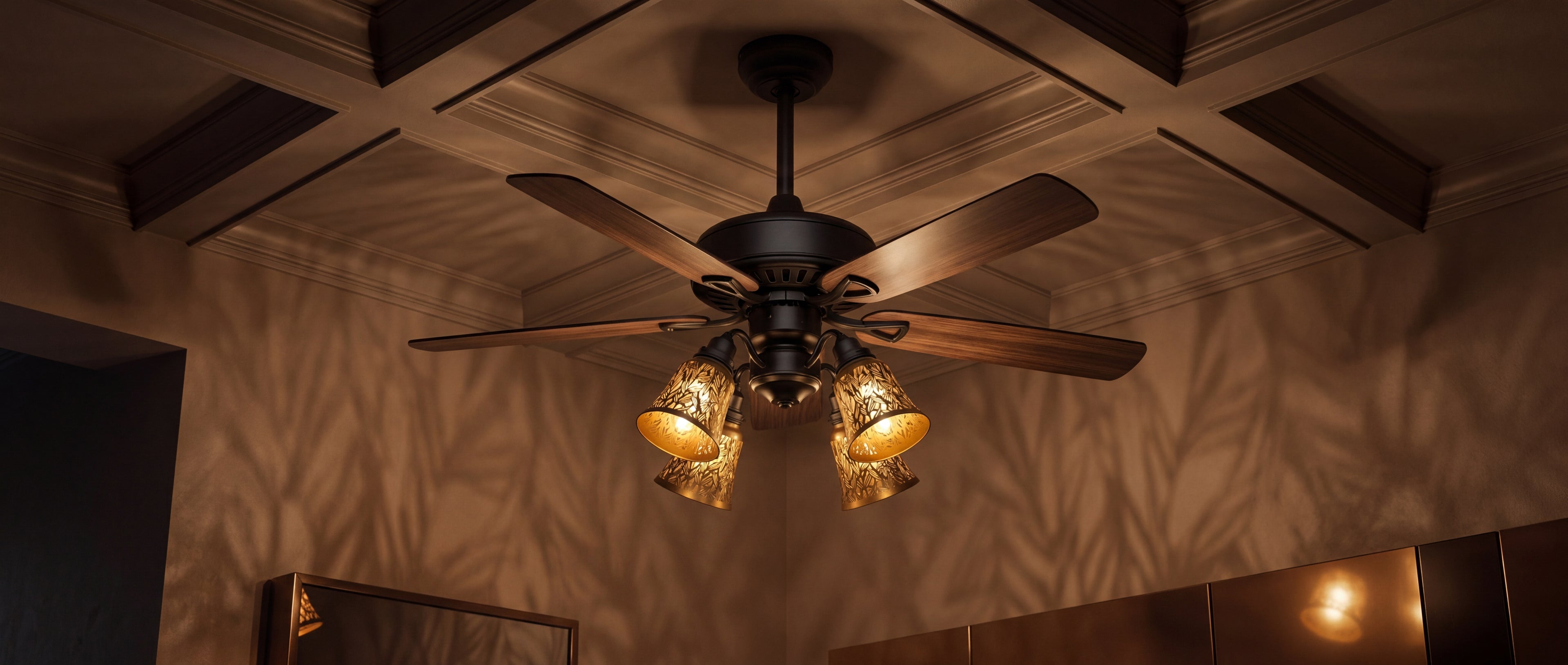 Clip-on small decorative metal lamp shade set of 4 pack installed on vintage dark bronze ceiling fan with four light kit, antique brass exterior gold interior laser-cut botanical leaf starfish pattern creating intricate warm leaf shadow pattern projection on beige coffered ceiling, four matching shades evenly illuminating the room, ideal lamp shade replacement for ceiling fan lights pendant lights chandeliers and wall sconces, retro warm lighting effect perfect for vintage modern American style home interio