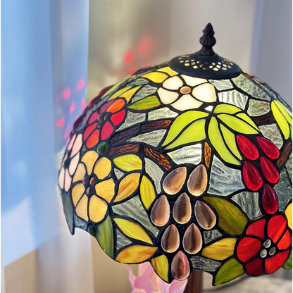 Tiffany style table lamp emitting warm and cheerful multicolor glow through floral stained glass shade
