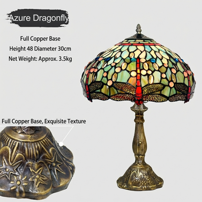 Close-up of handcrafted stained glass dragonfly shade in emerald green and ruby red tones with fine Art Nouveau detailing