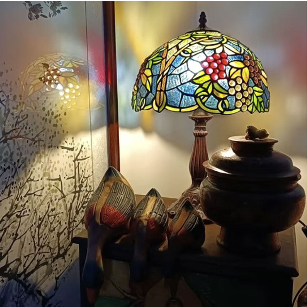 Tiffany style table lamp casting warm amber vineyard inspired glow through grape cluster stained glass shade