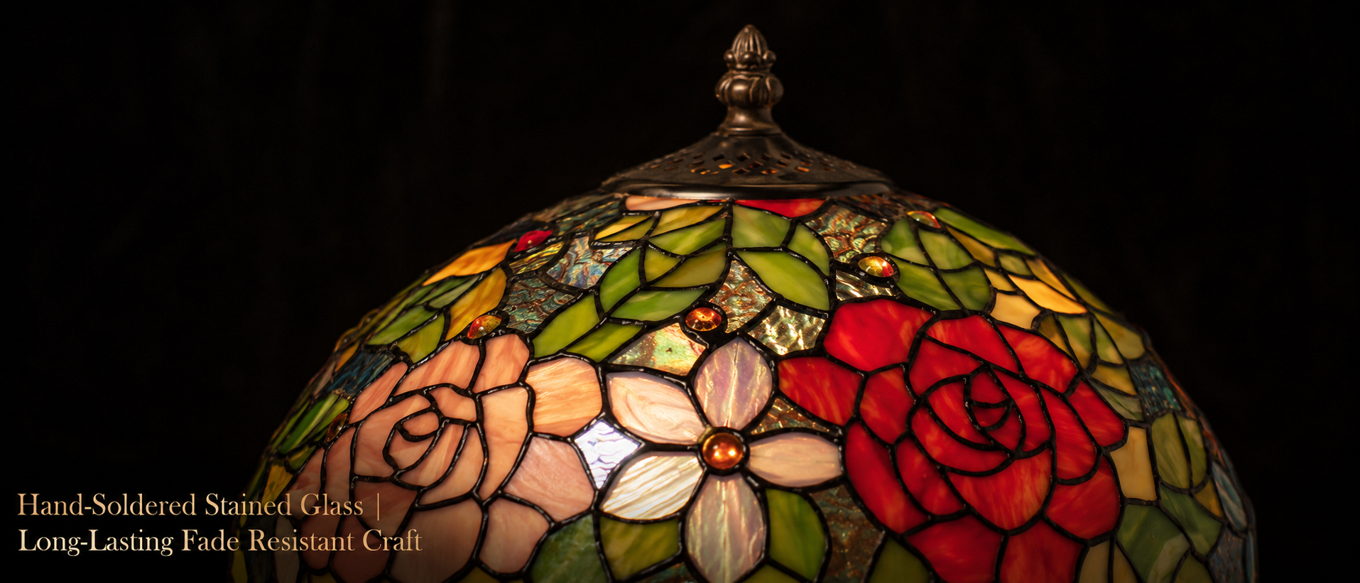 Close up of handcrafted floral stained glass shade featuring rose patterns and colorful artisan glass pieces