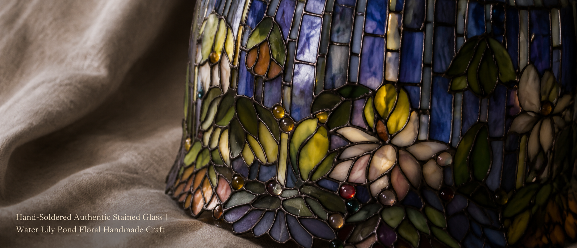 Close up of handcrafted water lily stained glass lamp shade featuring floral glass pieces and traditional Tiffany craftsmanship
