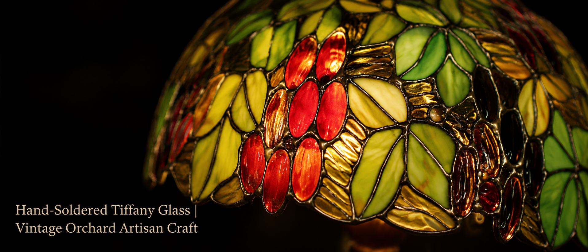 Handmade botanical stained glass lamp shade featuring orchard leaf patterns and ruby glass accents with artisan craftsmanship