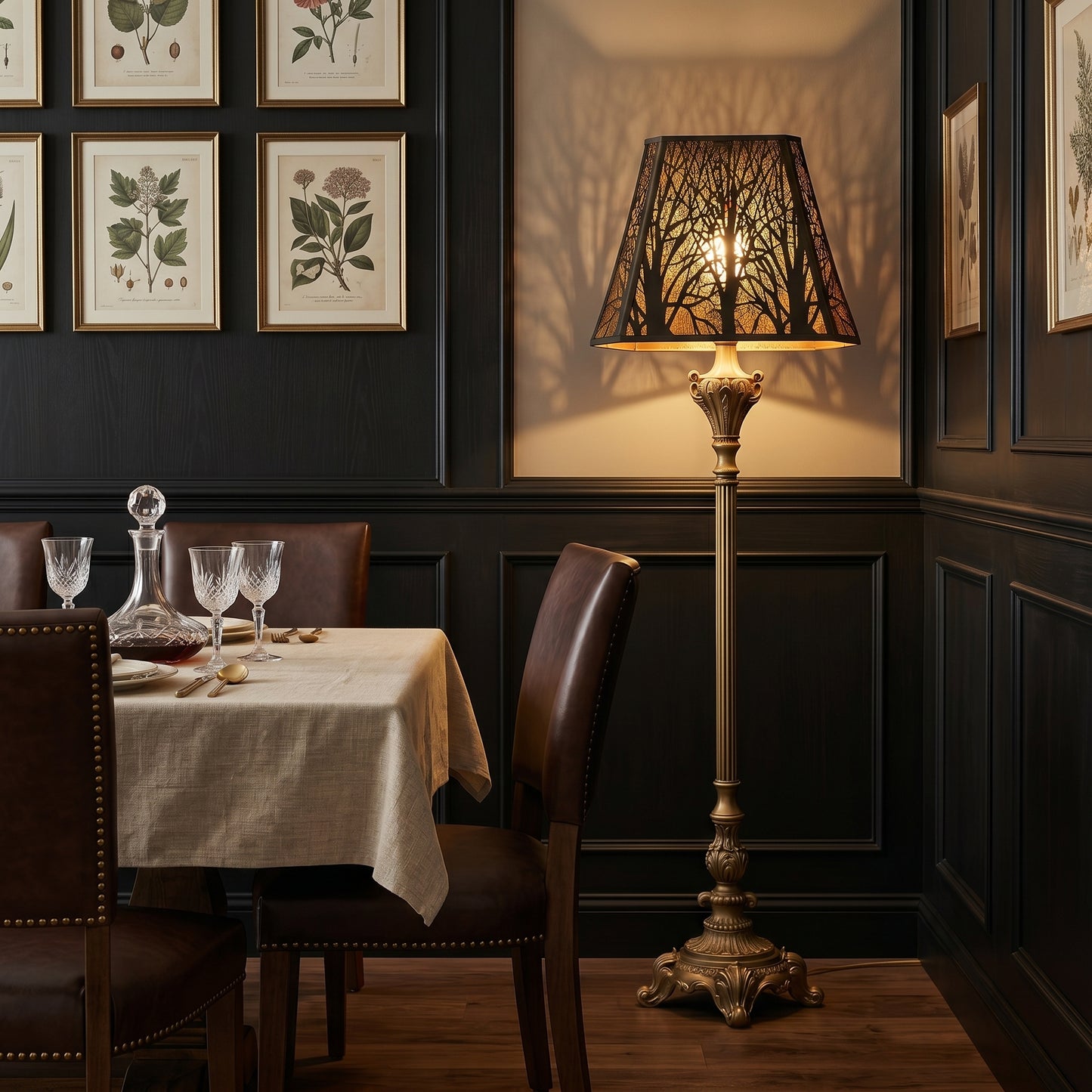 Antique bronze forest lamp shade on a large floor lamp beside a dining table, casting warm tree shadows on the wall