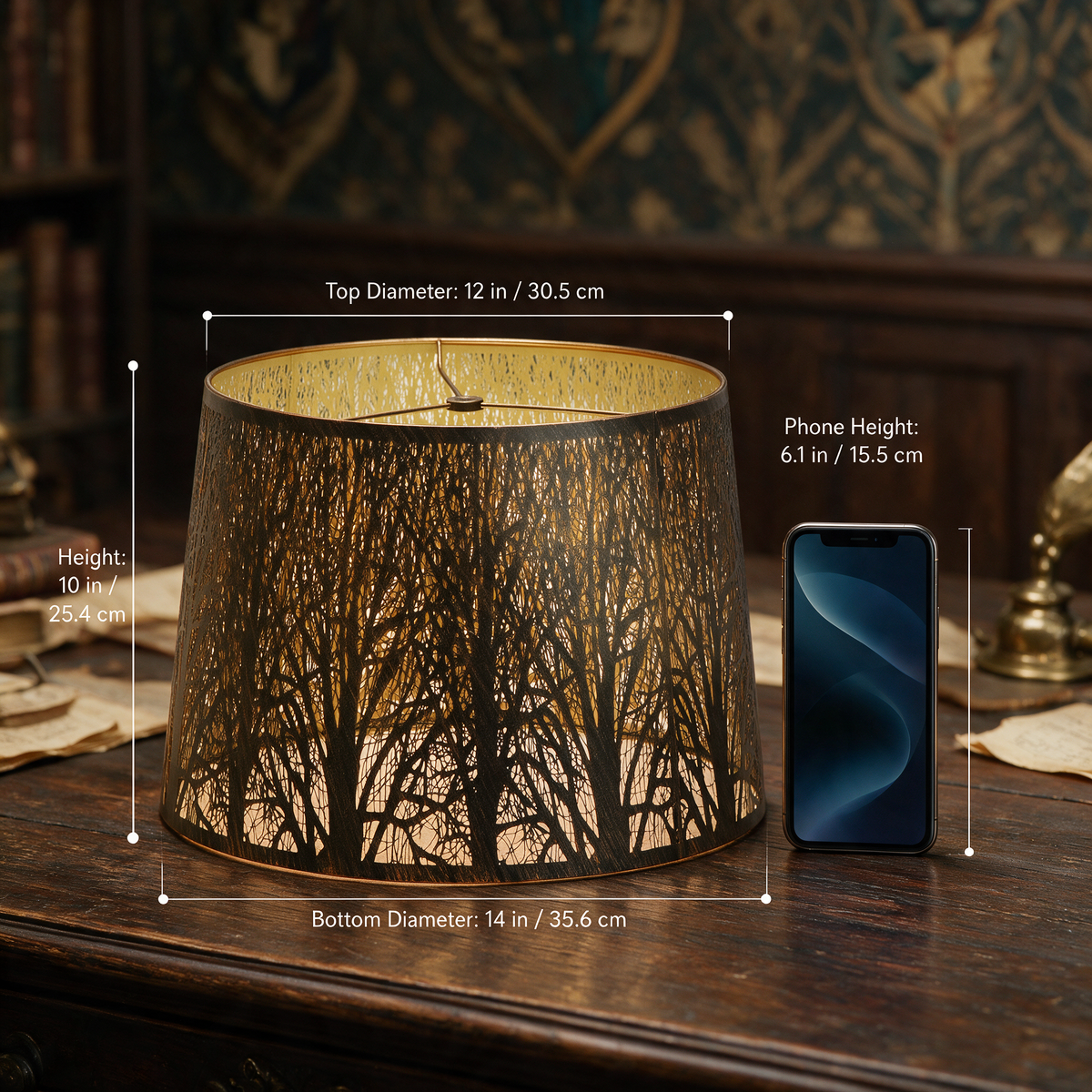 Large forest etched metal lampshade measuring 12-inch top, 14-inch bottom and 10-inch height beside a 6.1-inch phone.