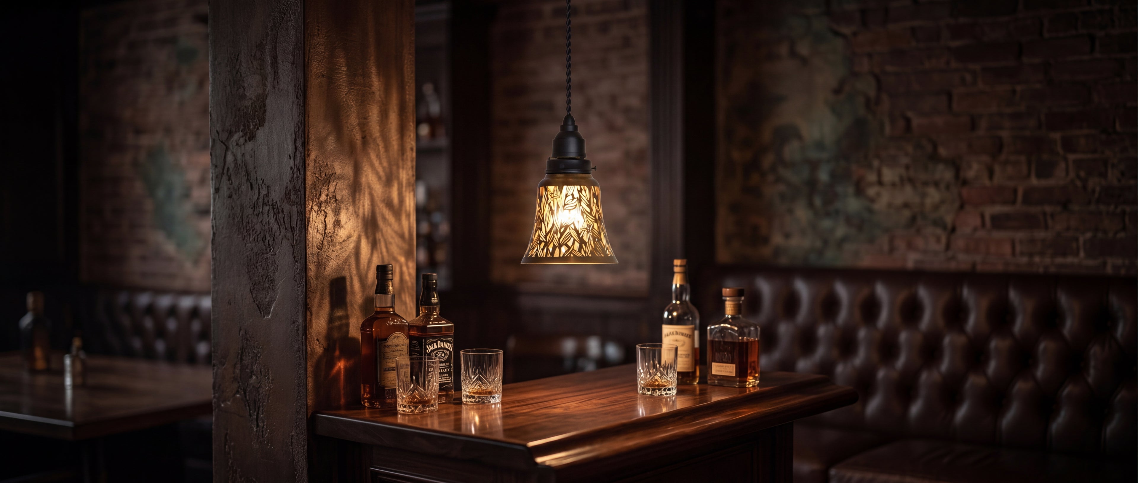 Laser-cut starburst metal lamp shade set of 4 pack clip-on small decorative shade, single pendant hanging light installed with antique bronze finish and gold interior botanical leaf starfish cutout design creating warm cinematic glow and relaxing shadow-play, vintage rustic bar lounge with exposed red brick wall dark leather tufted banquette seating whiskey bourbon scotch bottles and crystal whiskey glasses on wood bar counter, ideal lamp shade replacement for pendant light ceiling fan wall sconce and table