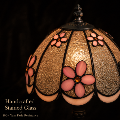Close-up of Tiffany style bedside lamp showing pink dimensional flowers and textured stained glass shade