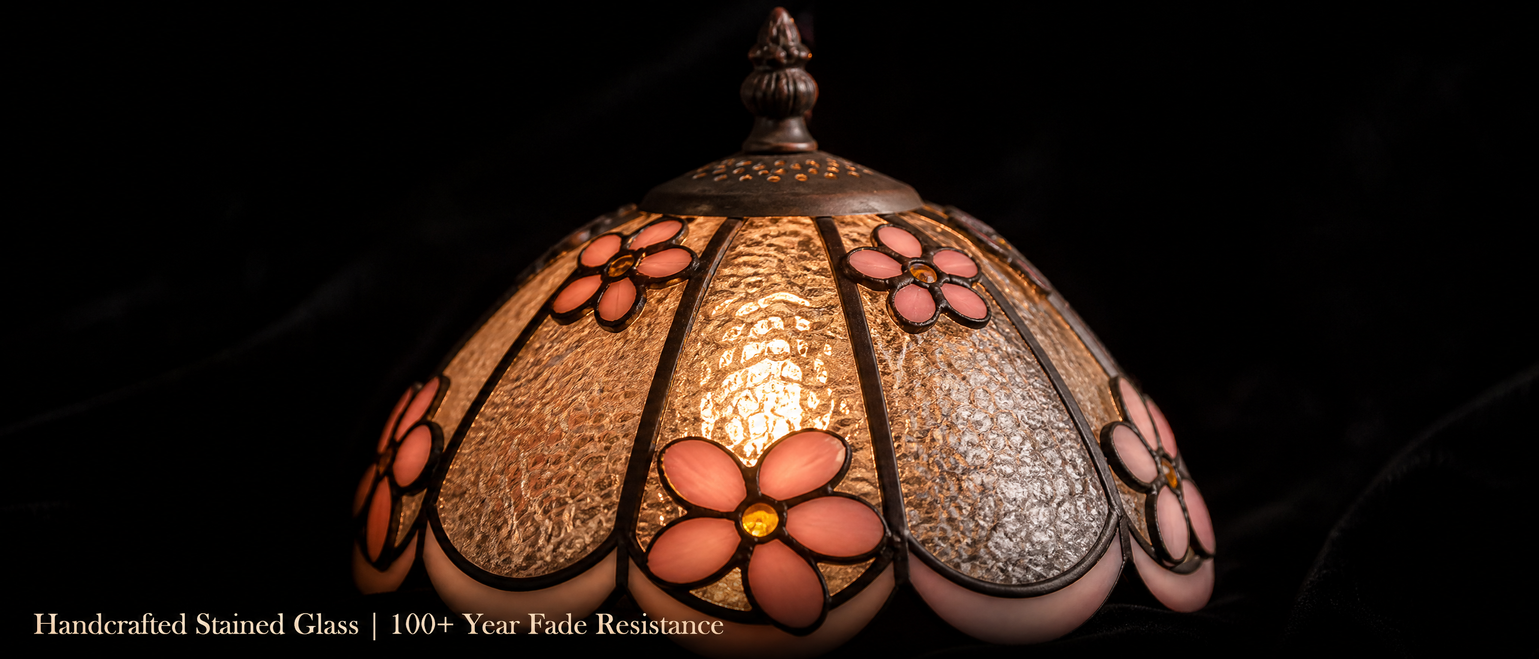 Close-up of Tiffany style bedside lamp showing pink flower accents and textured handcrafted stained glass shade