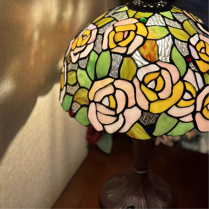 Tiffany style table lamp casting a warm romantic glow through pink rose stained glass for bedroom ambiance