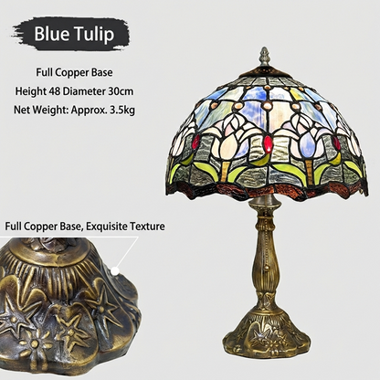 Tiffany style table lamp casting a soft calming glow through blue and white tulip stained glass in modern bedroom interior