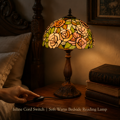 Pink rose Tiffany bedside lamp on bedroom nightstand providing soft warm reading light with handmade stained glass floral shade